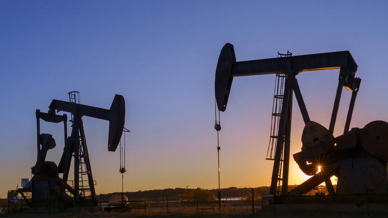 Silhouetted oil pumpjacks at sunset, symbolizing natural gas and energy production.