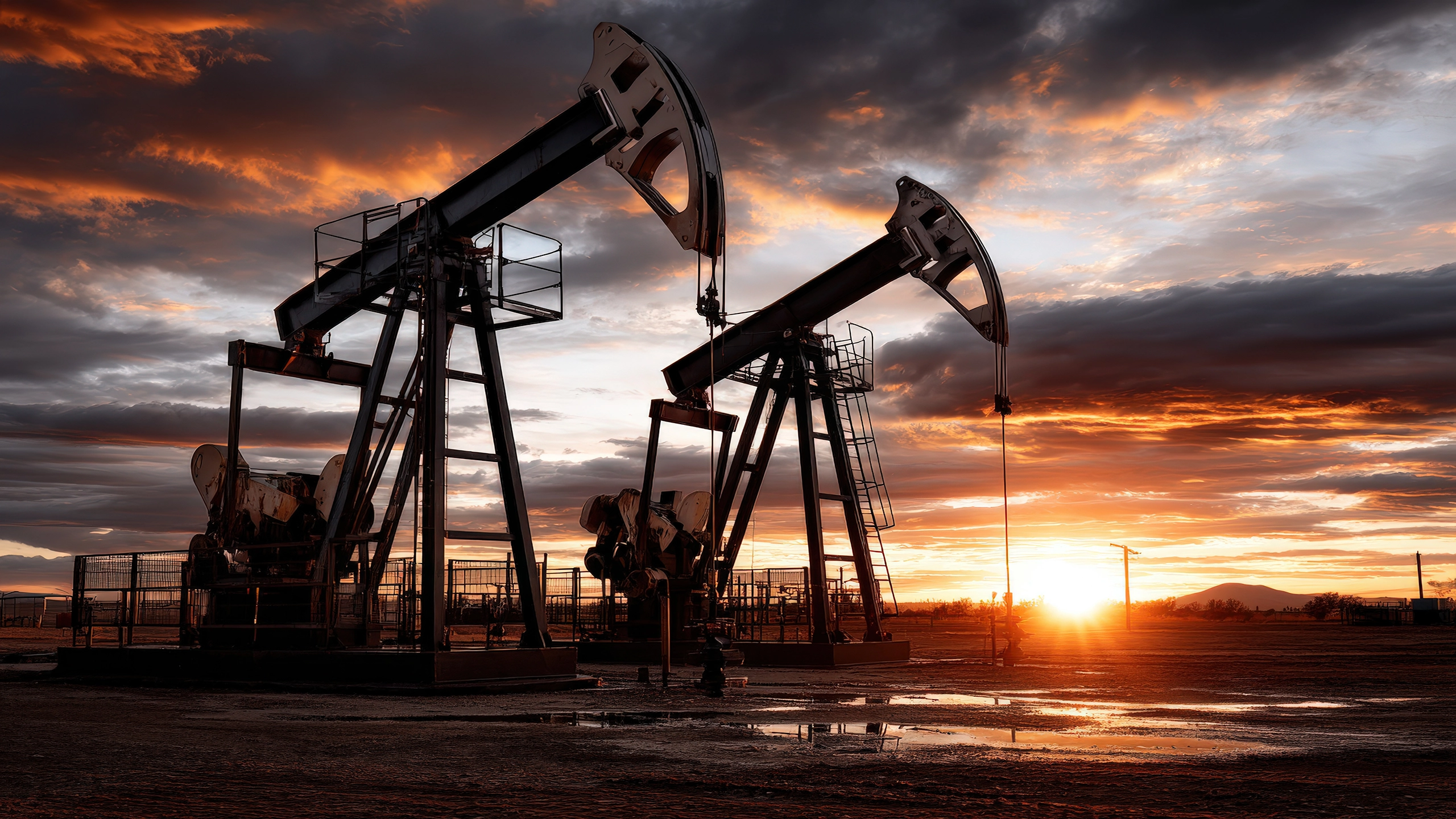 Oil pumpjack operating at an upstream production site at sunset